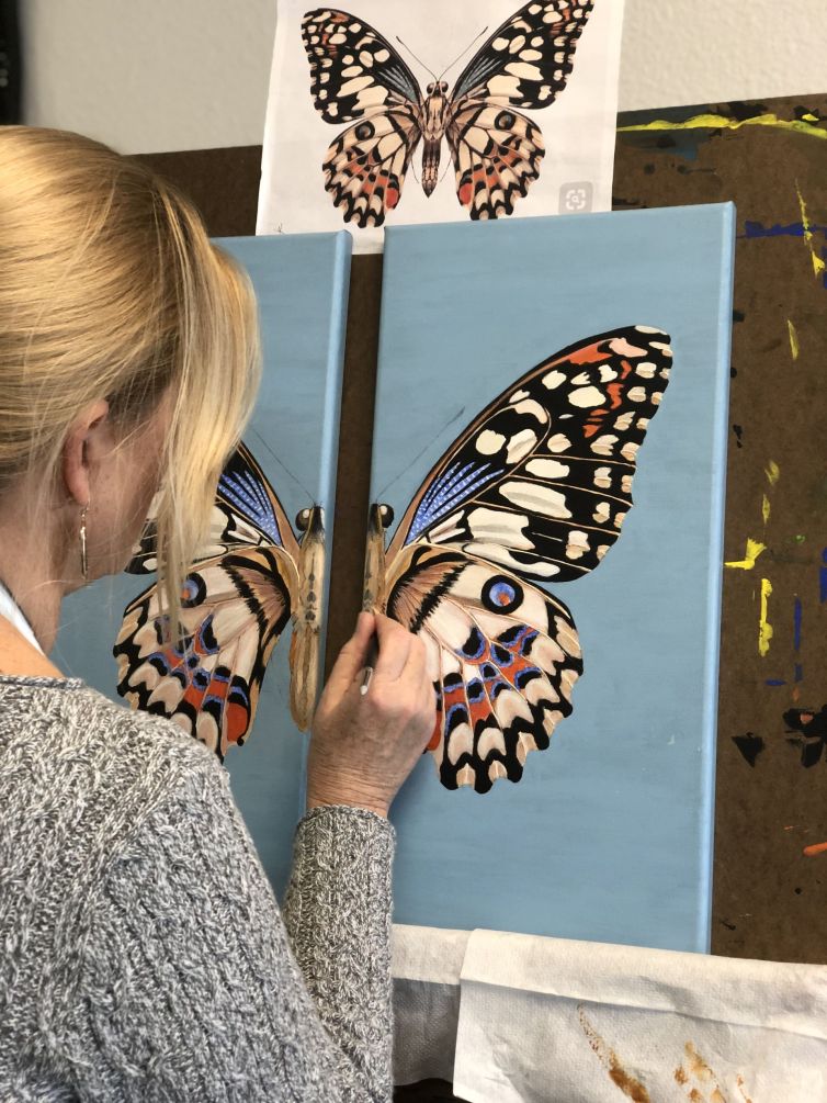 Adult painting a beautifully patterned butterfly during Art Class in Liberty Hill, showcasing precision and artistic growth