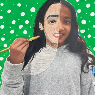 Young artist drawing half of their face over a self-photo using pastel during Art Class in South Austin, blending abstract and personal expression