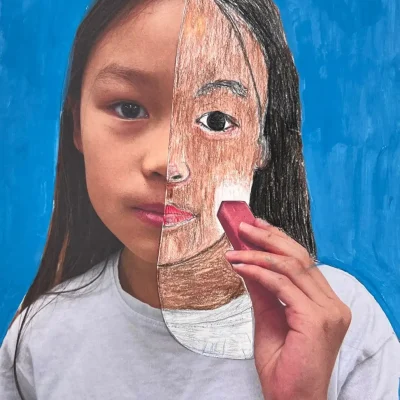 Young artist drawing half of their face over a self-photo using pastel during Art Class in South Austin, blending abstract and personal expression