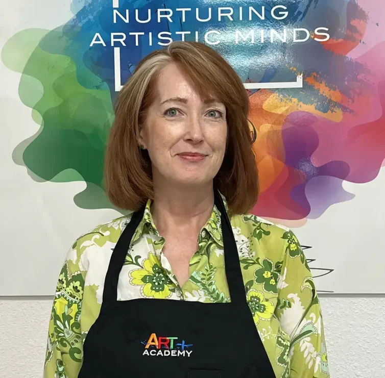 Professional portrait of art teacher with Art Plus Academy logo in the background at Southwest Austin location