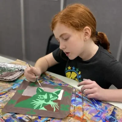 8_years_old_student_concentrated_in_art_project_with_tempera